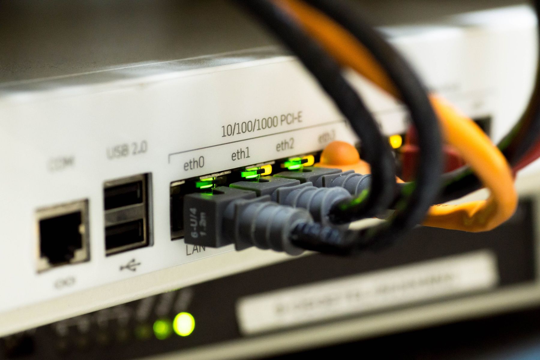 Network cables plugged into a router with link lights on
